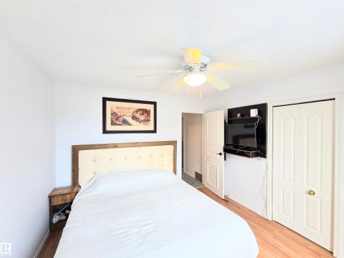 Bedroom with ceiling fan, light wood-type flooring, a closet, and a textured ceiling - 80 Amberly Crest, Edmonton, AB - Indoor Photo Showing Bedroom