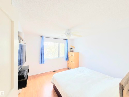 Bedroom featuring a ceiling fan, light wood-style floors, and a textured ceiling - 80 Amberly Crest, Edmonton, AB - Indoor Photo Showing Bedroom