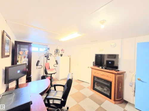 Office featuring light floors and a glass covered fireplace - 80 Amberly Crest, Edmonton, AB - Indoor With Fireplace