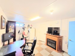 Office featuring light floors and a glass covered fireplace - 