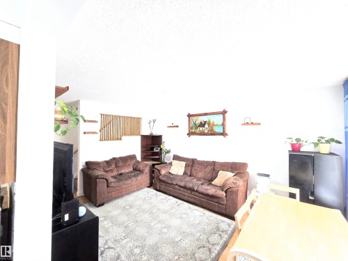 Living area with light wood-style floors and a textured ceiling - 80 Amberly Crest, Edmonton, AB - Indoor Photo Showing Living Room