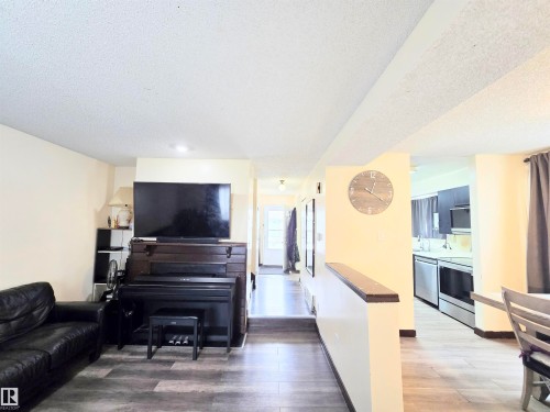 Living area featuring light wood-type flooring and a textured ceiling - 2 4403 Riverbend Road, Edmonton, AB - Indoor Photo Showing Living Room