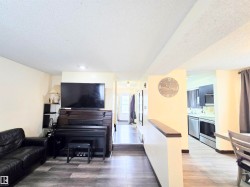 Living area featuring light wood-type flooring and a textured ceiling - 