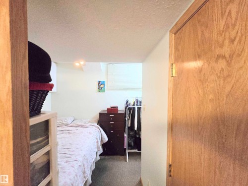 Carpeted bedroom featuring a textured ceiling - 2 4403 Riverbend Road, Edmonton, AB - Indoor Photo Showing Bedroom