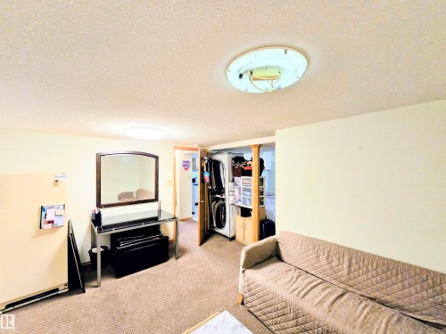 Carpeted living room featuring a textured ceiling - 2 4403 Riverbend Road, Edmonton, AB - Indoor