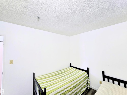 Bedroom featuring a textured ceiling - 2 4403 Riverbend Road, Edmonton, AB - Indoor Photo Showing Bedroom