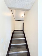 Stairway featuring a textured ceiling - 