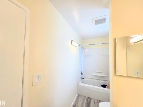 Full bath featuring washtub / shower combination and light wood-type flooring - 2 4403 Riverbend Road, Edmonton, AB - Indoor Photo Showing Bathroom