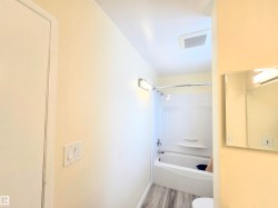Full bath featuring washtub / shower combination and light wood-type flooring - 