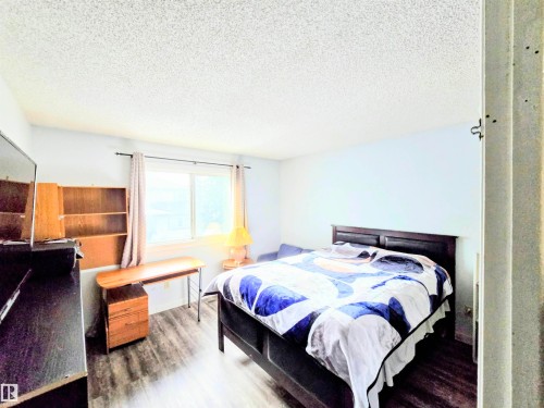 Bedroom featuring a textured ceiling and wood finished floors - 2 4403 Riverbend Road, Edmonton, AB - Indoor Photo Showing Bedroom