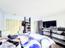 Bedroom with a closet, a textured ceiling, and wood finished floors - 