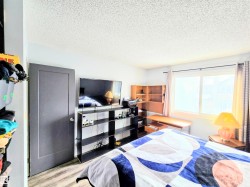 Bedroom with light wood-style floors and a textured ceiling - 