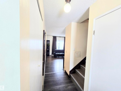 Hallway featuring a textured ceiling and dark wood-type flooring - 2 4403 Riverbend Road, Edmonton, AB - Indoor Photo Showing Other Room