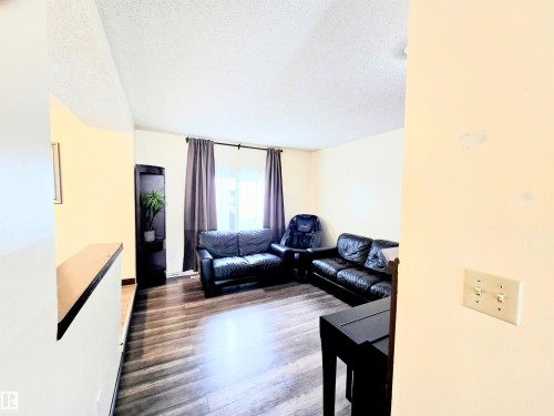 Living room with a textured ceiling and dark wood finished floors - 2 4403 Riverbend Road, Edmonton, AB - Indoor Photo Showing Living Room