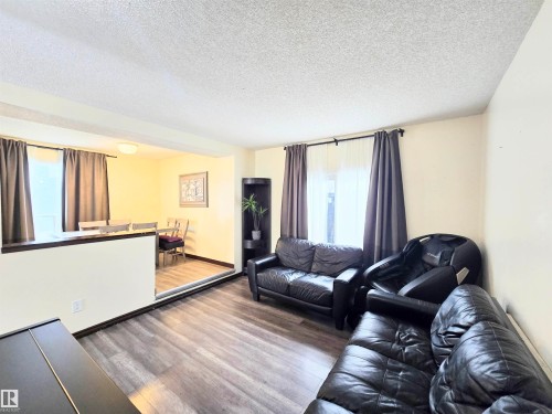 Living room with dark wood finished floors and a textured ceiling - 2 4403 Riverbend Road, Edmonton, AB - Indoor Photo Showing Living Room