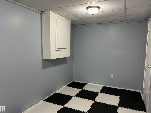 Finished basement with a paneled ceiling and dark floors - 17 9520 174 Street, Edmonton, AB - Indoor Photo Showing Other Room