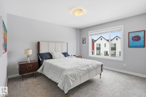 Carpeted bedroom featuring a textured ceiling and baseboards - 90 1010 Rabbit Hill Road, Edmonton, AB - Indoor Photo Showing Bedroom