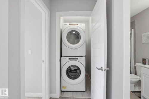 Laundry area featuring a textured ceiling and stacked washer / drying machine - 90 1010 Rabbit Hill Road, Edmonton, AB - Indoor Photo Showing Laundry Room
