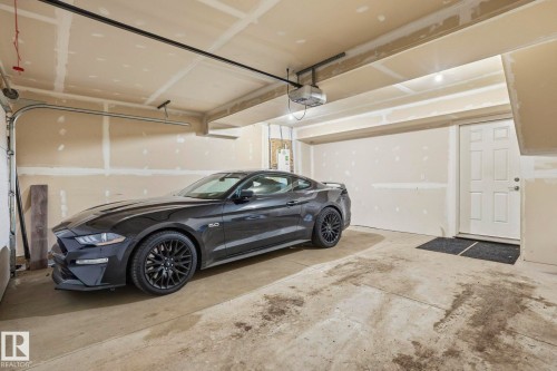 Garage featuring water heater and a garage door opener - 90 1010 Rabbit Hill Road, Edmonton, AB - Indoor Photo Showing Garage