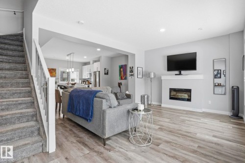 Living room featuring light wood finished floors, a glass covered fireplace, and recessed lighting - 90 1010 Rabbit Hill Road, Edmonton, AB - Indoor Photo Showing Living Room With Fireplace