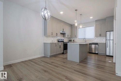Kitchen with a center island, gray cabinets, stainless steel appliances, and light countertops - 3520 Kulay Link Link, Edmonton, AB - Indoor Photo Showing Kitchen With Upgraded Kitchen