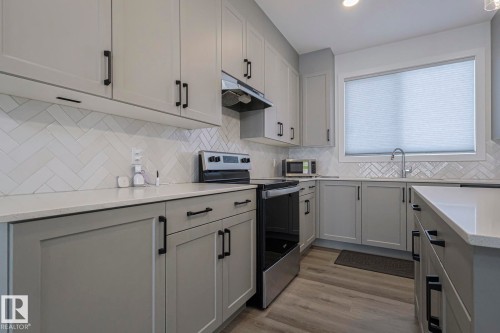 Kitchen featuring stainless steel appliances, gray cabinets, light wood-style flooring, light stone countertops, and recessed lighting - 3520 Kulay Link Link, Edmonton, AB - Indoor Photo Showing Kitchen With Upgraded Kitchen