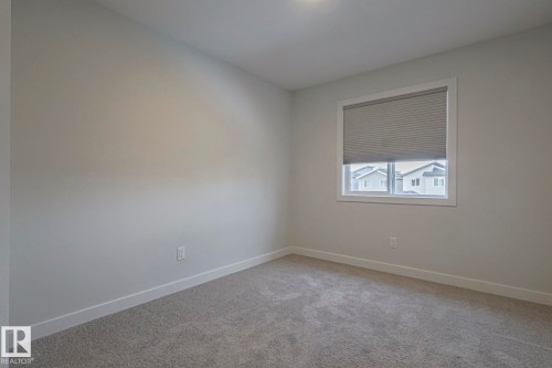 Empty room featuring light carpet and baseboards - 3520 Kulay Link Link, Edmonton, AB - Indoor Photo Showing Other Room