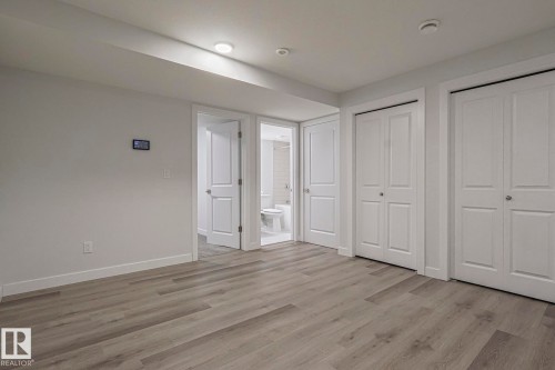 Unfurnished bedroom featuring light wood-style flooring, ensuite bathroom, and multiple closets - 3520 Kulay Link Link, Edmonton, AB - Indoor Photo Showing Other Room