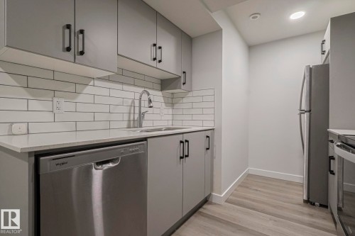 Kitchen featuring gray cabinets, stainless steel appliances, light wood-style flooring, backsplash, and light stone counters - 3520 Kulay Link Link, Edmonton, AB - Indoor Photo Showing Kitchen With Upgraded Kitchen