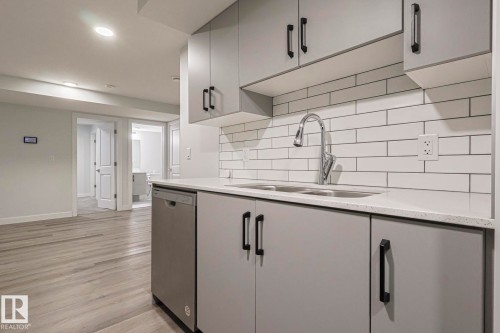 Kitchen featuring gray cabinets, dishwasher, light wood-style floors, light stone counters, and recessed lighting - 3520 Kulay Link Link, Edmonton, AB - Indoor Photo Showing Kitchen With Double Sink