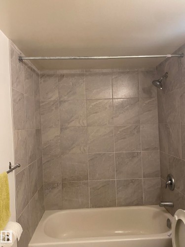 Bathroom featuring toilet and bathtub / shower combination - 205 10345 123 Street, Edmonton, AB - Indoor Photo Showing Bathroom