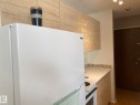 Kitchen featuring white appliances, light countertops, and light wood finish cabinetry - 205 10345 123 Street, Edmonton, AB  - Indoor Photo Showing Kitchen 