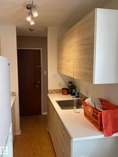 Kitchen with light countertops, freestanding refrigerator, and light floors - 205 10345 123 Street, Edmonton, AB - Indoor Photo Showing Kitchen