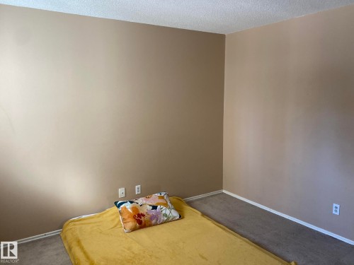 Bedroom featuring dark carpet and a textured ceiling - 205 10345 123 Street, Edmonton, AB - Indoor Photo Showing Bedroom