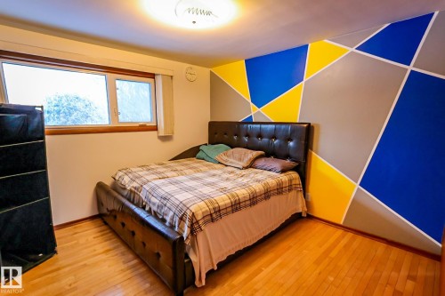 Bedroom featuring hardwood / wood-style flooring and an accent wall - 4812 51 Avenue, Vilna, AB - Indoor Photo Showing Bedroom