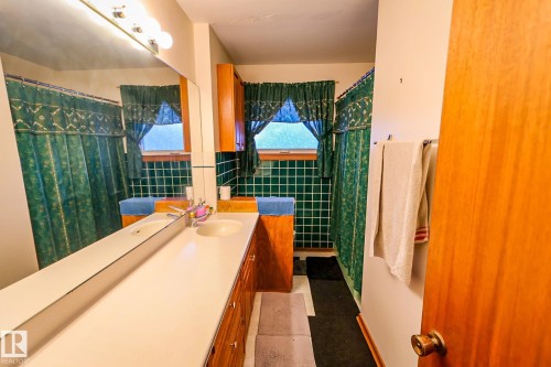 Bathroom with vanity, curtained shower, and tile walls - 4812 51 Avenue, Vilna, AB - Indoor Photo Showing Bathroom