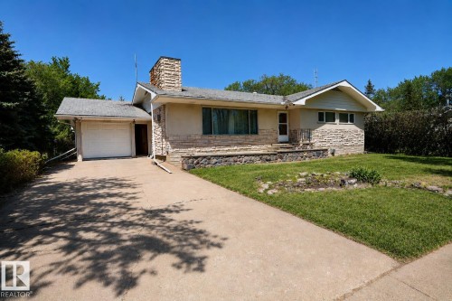Ranch-style residence featuring a prominent stone chimney and a combination of stucco and horizontal stone siding - 4812 51 Avenue, Vilna, AB - Outdoor