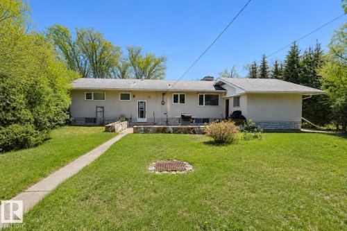Spacious backyard featuring a concrete pathway, a built-in fire pit, stone-accented exterior walls, and a private patio area - 4812 51 Avenue, Vilna, AB - Outdoor