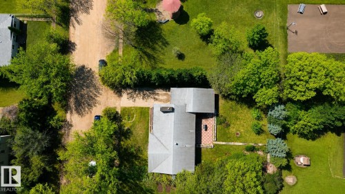 Property featuring a light gray roof, mature trees, and a patterned patio - 4812 51 Avenue, Vilna, AB - Outdoor