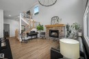 Living room featuring a fireplace, wood finished floors, suspended lighting, and a high ceiling - 34 Riverhill Crescent, St. Albert, AB  - Indoor With Fireplace 