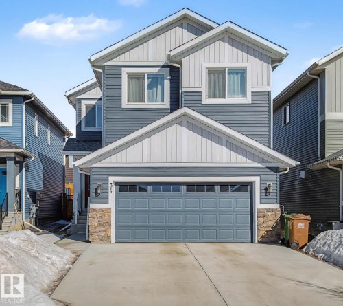 Craftsman house featuring stone siding, board and batten siding, driveway, and a garage - 34 Riverhill Crescent, St. Albert, AB - Outdoor