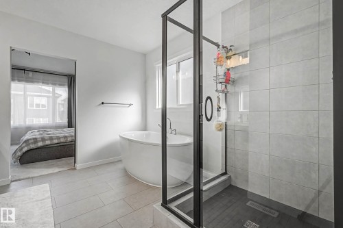 Ensuite bathroom with a stall shower, plenty of natural light, a freestanding bath, and light tile patterned flooring - 34 Riverhill Crescent, St. Albert, AB - Indoor Photo Showing Bathroom