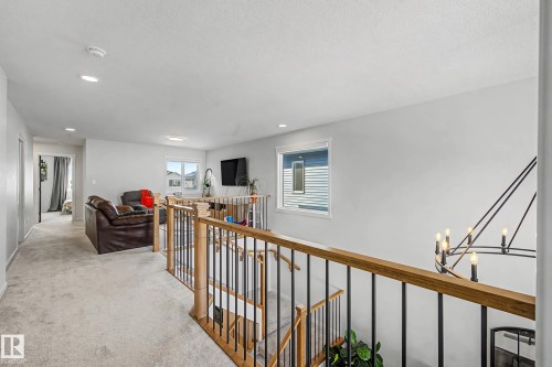 Hallway with an upstairs landing, light carpet, and a chandelier - 34 Riverhill Crescent, St. Albert, AB - Indoor Photo Showing Other Room