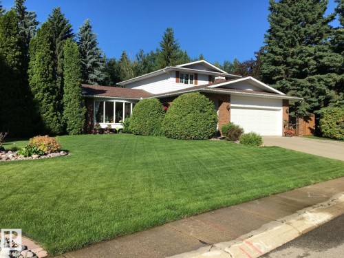 View of front of property with an attached garage, a front lawn, driveway, and brick siding - 206 Wolf Willow Crescent, Edmonton, AB - Outdoor