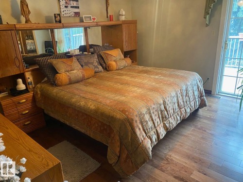 Bedroom with dark wood finished floors, access to outside, and multiple windows - 206 Wolf Willow Crescent, Edmonton, AB - Indoor Photo Showing Bedroom