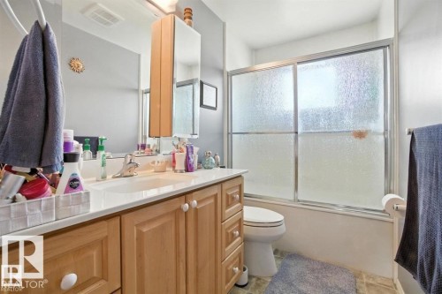 Bathroom featuring vanity, enclosed tub / shower combo, and light tile patterned floors - 14936 81 Street, Edmonton, AB - Indoor Photo Showing Bathroom