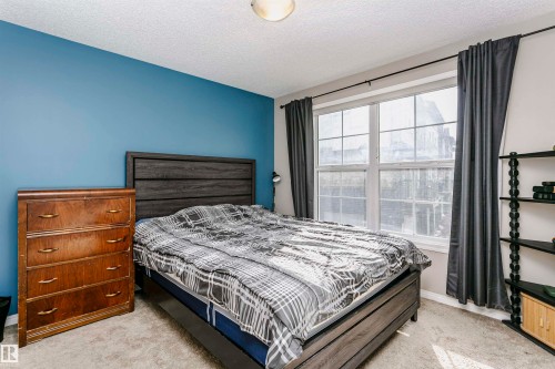 Bedroom featuring light carpet and a textured ceiling - 4011 Orchards Drive, Edmonton, AB - Indoor Photo Showing Bedroom