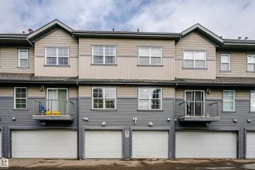 Rear view of house with board and batten siding, an attached garage, and driveway - 4011 Orchards Drive, Edmonton, AB - Outdoor With Facade