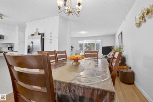 Dining area with light wood-style floors, a textured ceiling, and hanging lights - 17303 101 Street, Edmonton, AB - Indoor Photo Showing Dining Room