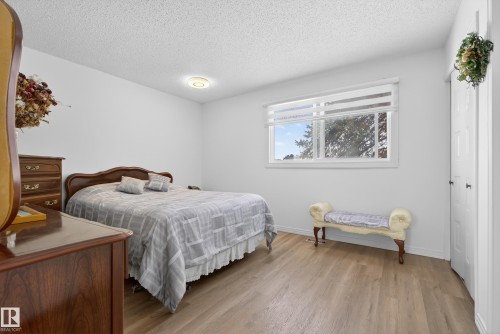 Bedroom featuring a textured ceiling, light wood-style floors, and a closet - 17303 101 Street, Edmonton, AB - Indoor Photo Showing Bedroom